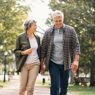 Retired couple walking and smiling, knowing their retirement goals are protected by a Protective Dimensions V variable annuity.
