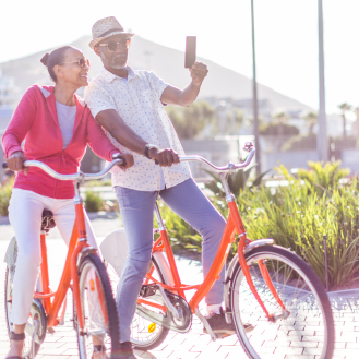 Retired couple pauses during a bike ride to take a selfie happy knowing their income is protected with Protective Income Creator Fixed Annuity.