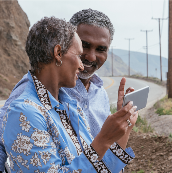 A couple at a scenic roadside overlook prepare to take a picture.