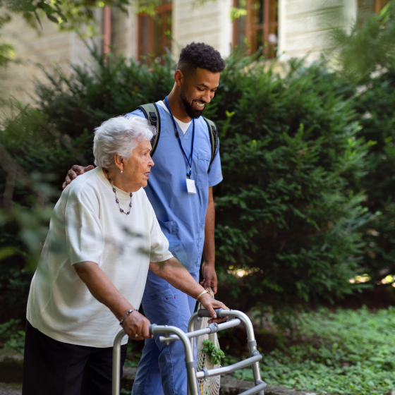Older woman being helped by a nursing home assistant, using the SecurePay NH benefit