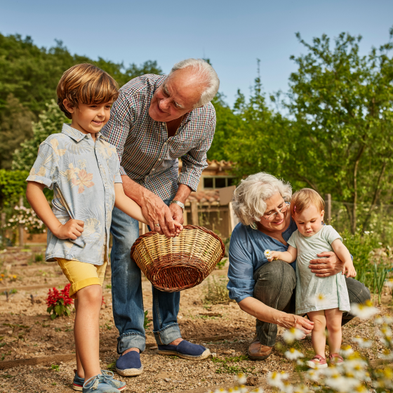 Grandparents enjoying spending time with their grandchildren outdoors, happy they've used Protective® Dimensions V variable annuity death benefit options to secure their legacy