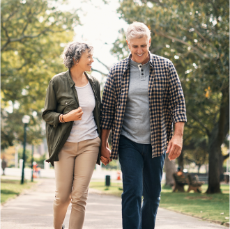 retired couple walking and smiling, knowing their retirement goals are protected by a Protective Dimensions IV variable annuity.