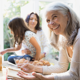 grandmother, who represents a potential Protective Secure Saver fixed annuity client,reviews recipe while cooking with daughter and granddaughter.