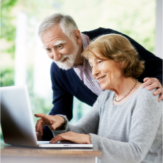 Couple exploring guaranteed income options on their laptop.