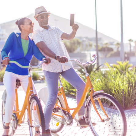 Retired couple pauses during a bike ride to take a selfie happy knowing their income is protected with Protective Income Creator Fixed Annuity.