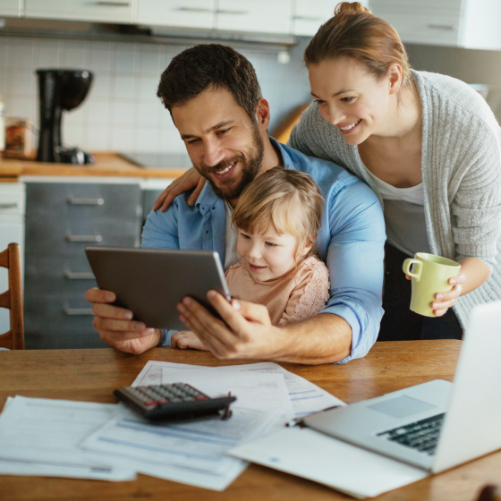 A husband and wife holding their young daughter and reviewing information about term life insurance