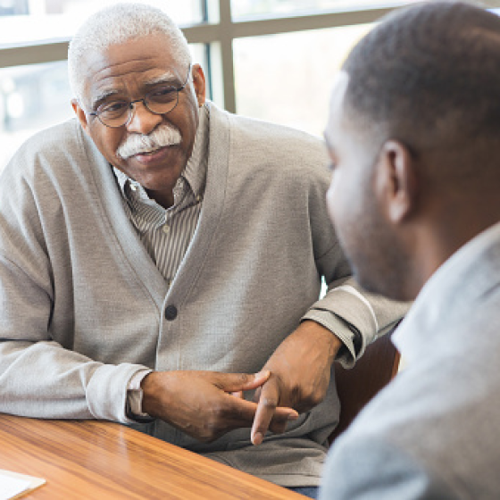  Financial representative speaking with client about his legacy planning needs.